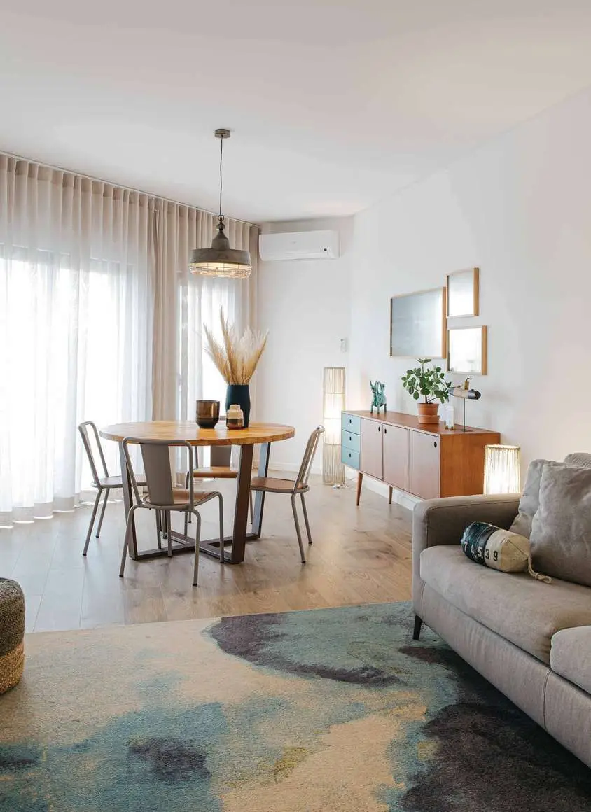 Sala de um apartamento do You and the Sea, com mesa de jantar e sofá