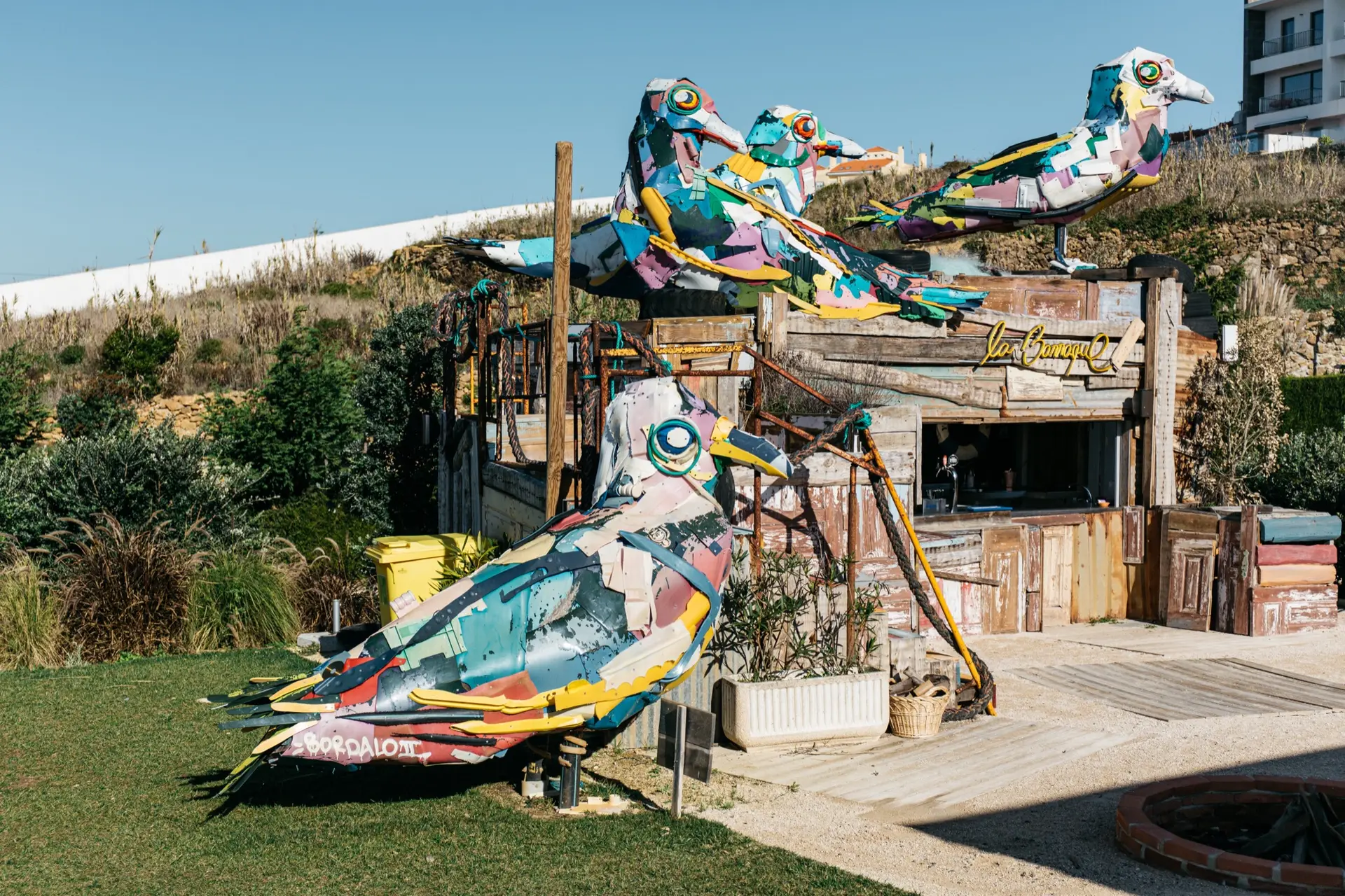 O bar La Barraque de dia, com os pássaros coloridos feitos de materiais reciclados