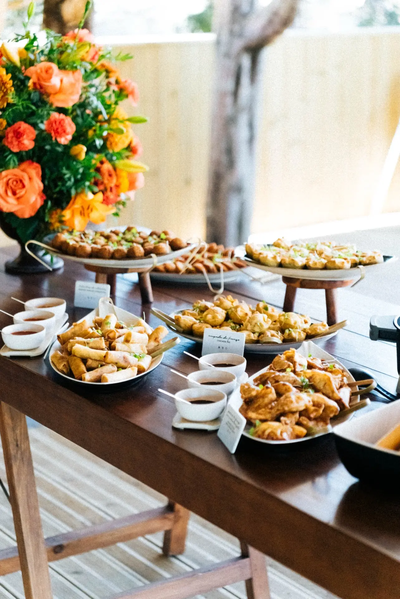 Mesa de buffet com petiscos e flores