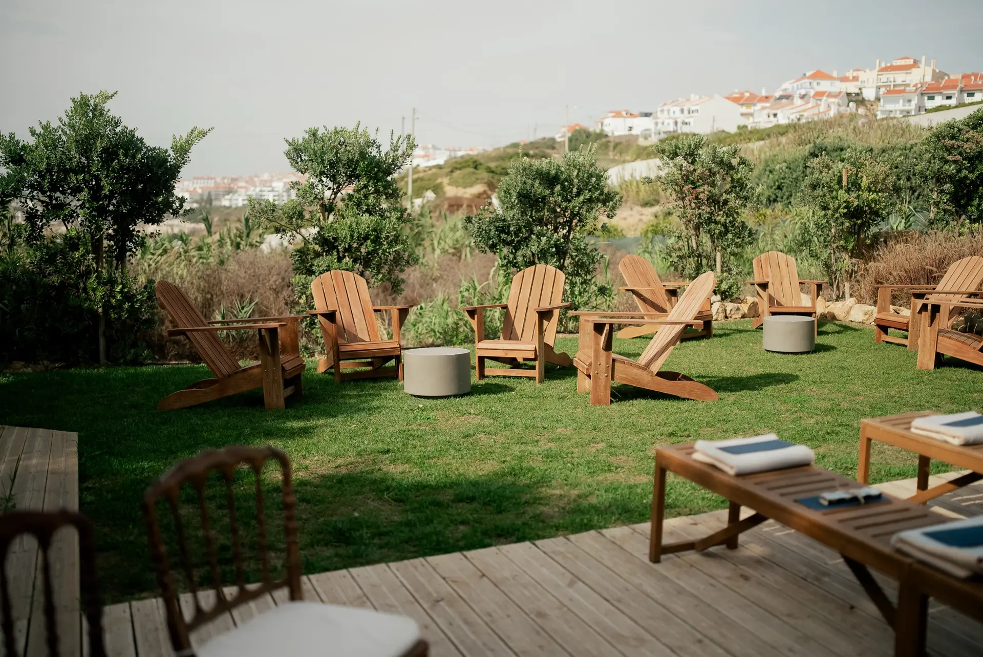 Relvado com cadeiras de madeira e mesas baixas preparadas para um casamento